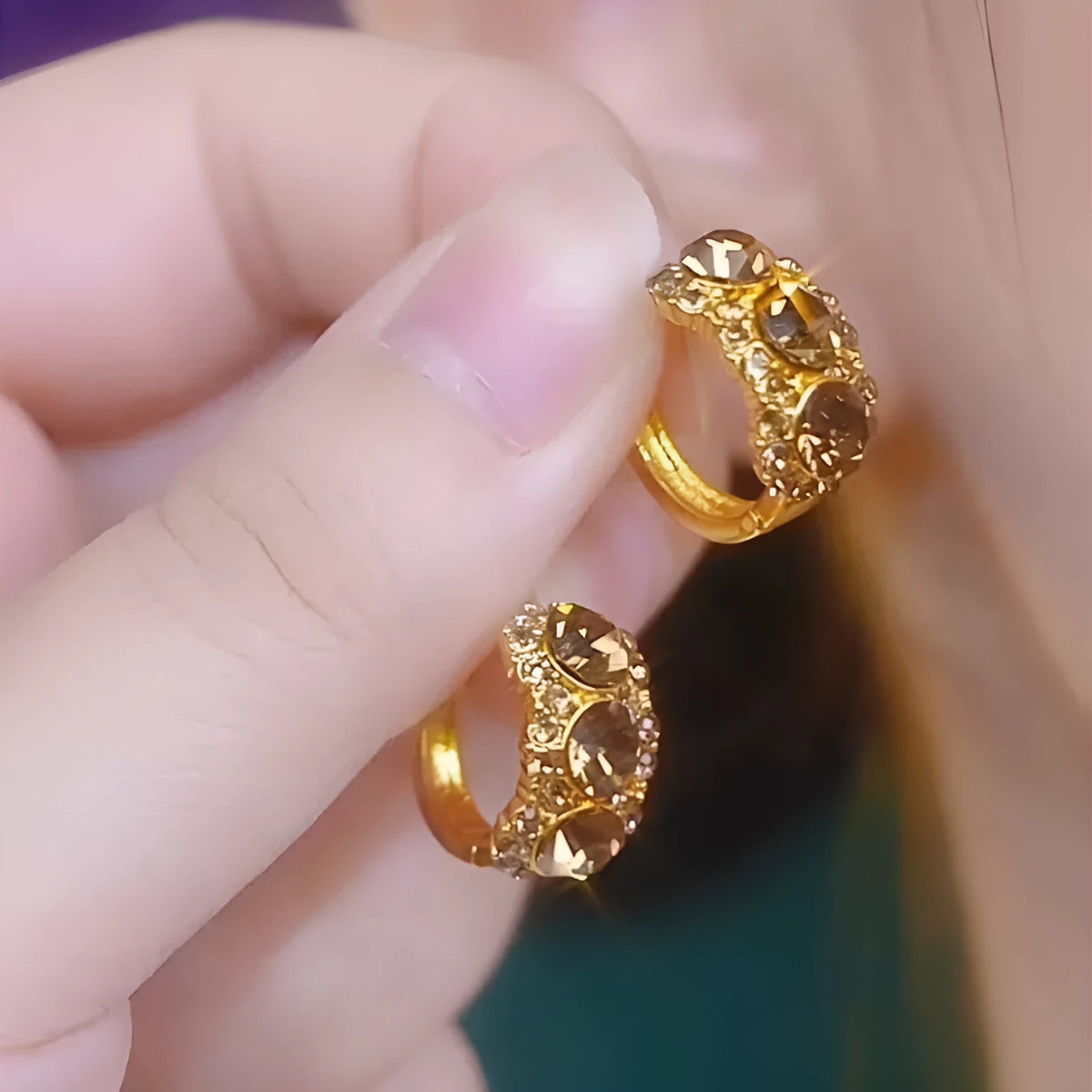 Gold metal hoop earrings with diamond surface treatment and brown zircon stones