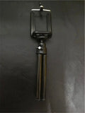 Black and silver desktop phone holder with a two-section bracket on a wooden desk.