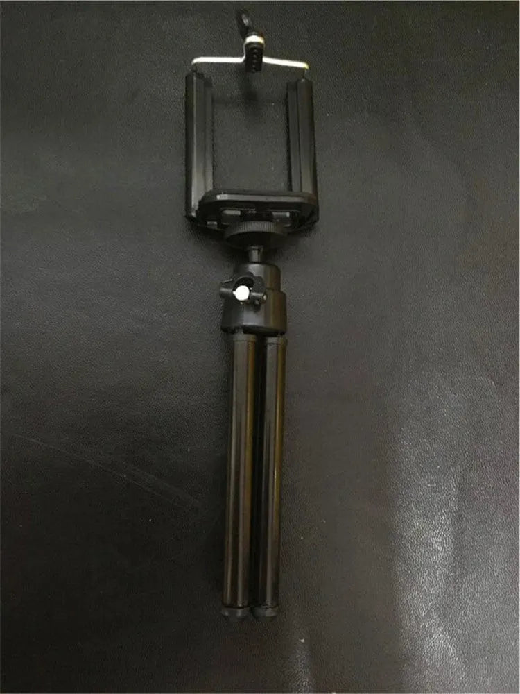 Black and silver desktop phone holder with a two-section bracket on a wooden desk.