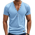 Man wearing a loose fit grey v-neck pullover top with button detail on the neckline