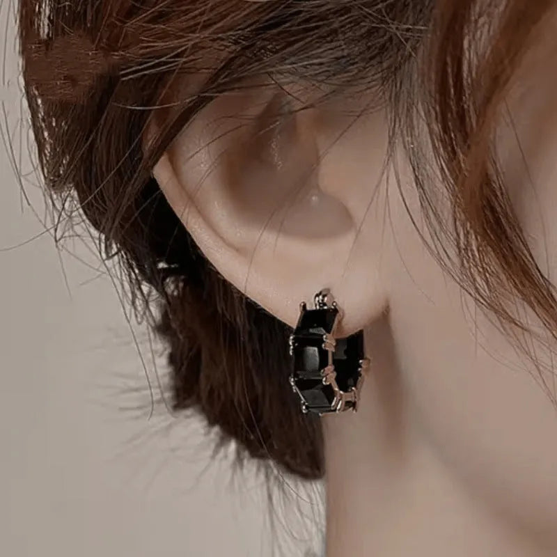 Geometric U-shaped gold tone earrings with round black zircon stone.