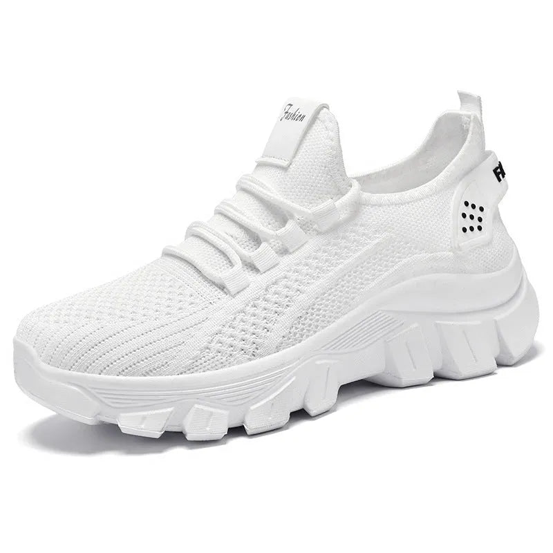 Women's white Flyknit lace-up sneakers with a thick PVC sole and round toe on a neutral background.