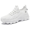 Women's white Flyknit lace-up sneakers with a thick PVC sole and round toe on a neutral background.