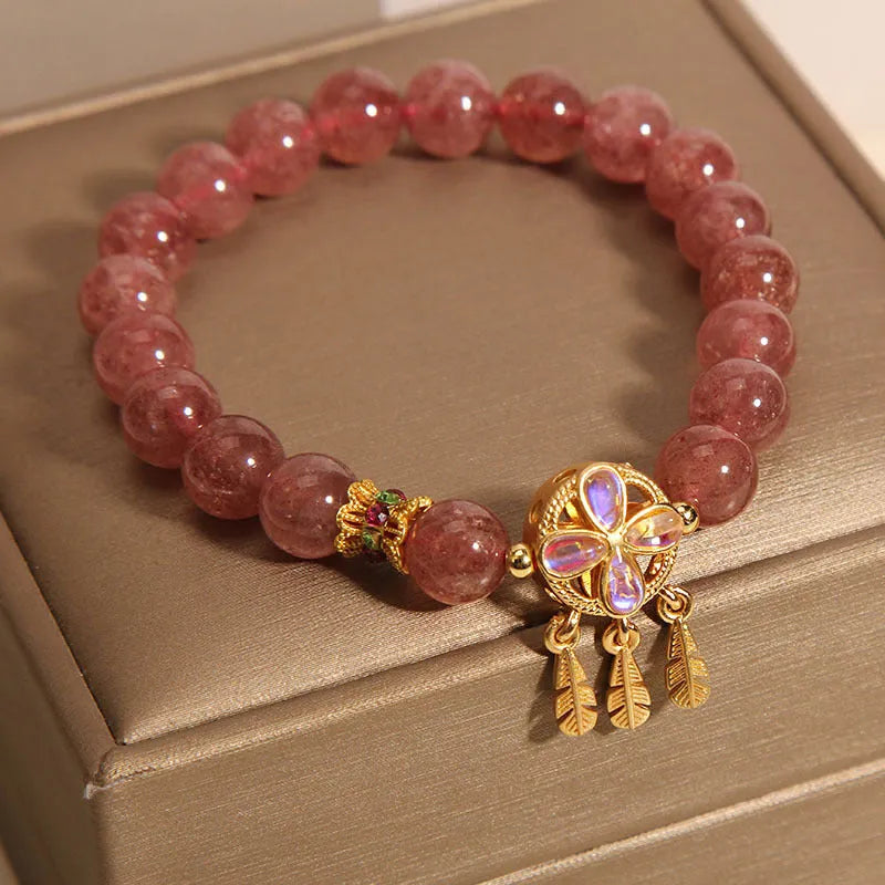 Women's strawberry quartz crystal bracelet with a four leaf dream catcher ball pendant.
