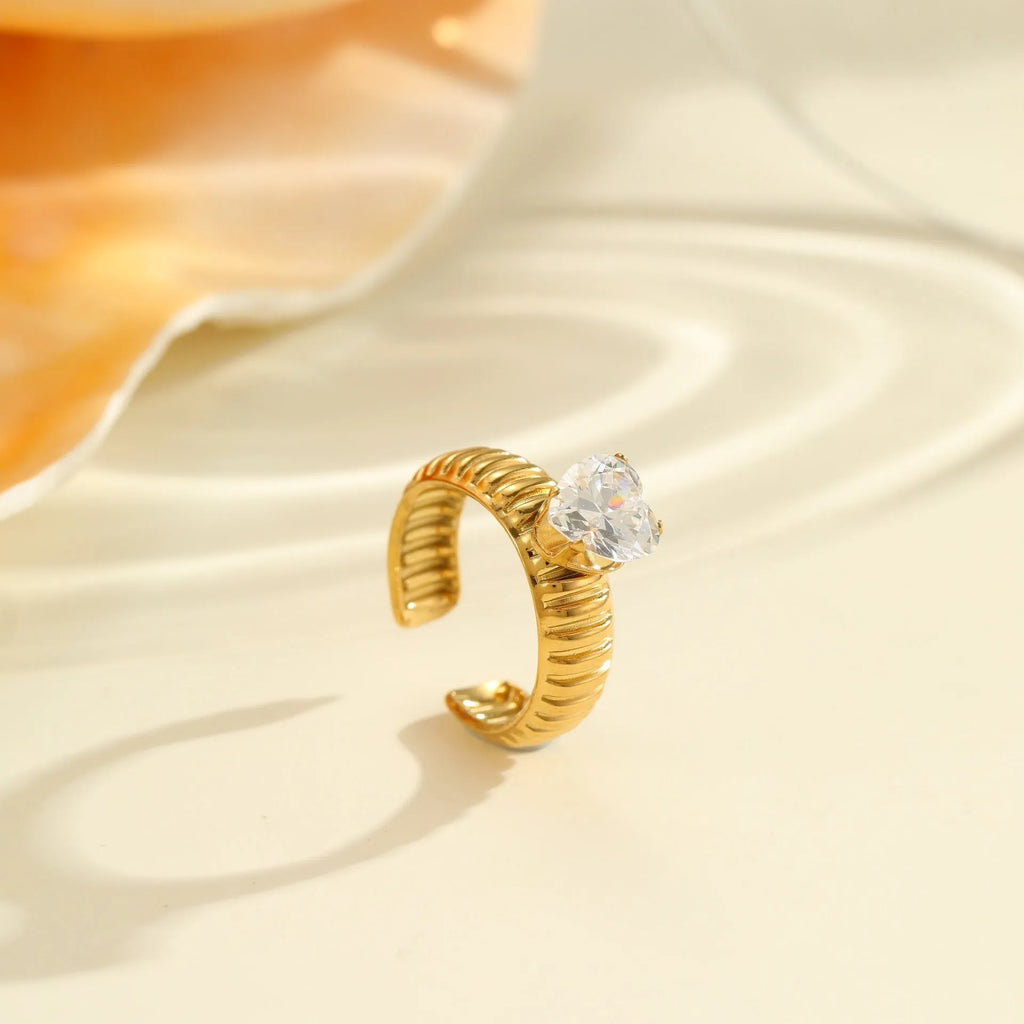 Gold-inlaid zircon geometric stainless steel ring with open mouth design on a white background.