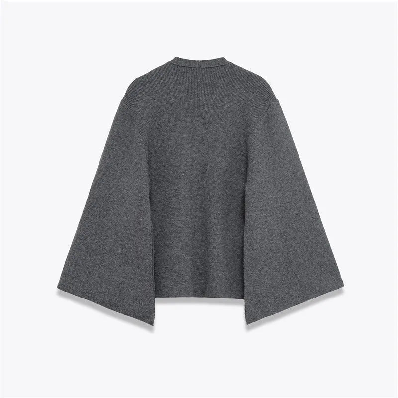 Women's long gray knitted coat with slit sleeves and pockets on display