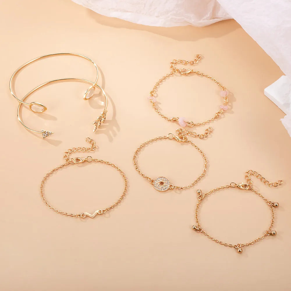 Set of six gold fashion bracelets with water droplet, arrow, V-shape and drill designs.
