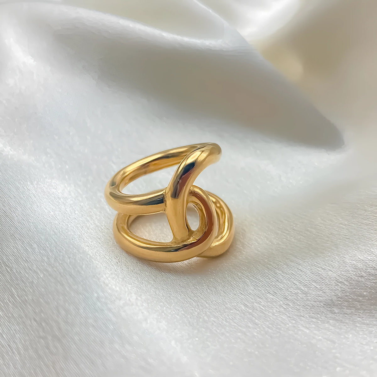 Adjustable stainless steel ring with knot design in U-shape, available in gold or steel colour