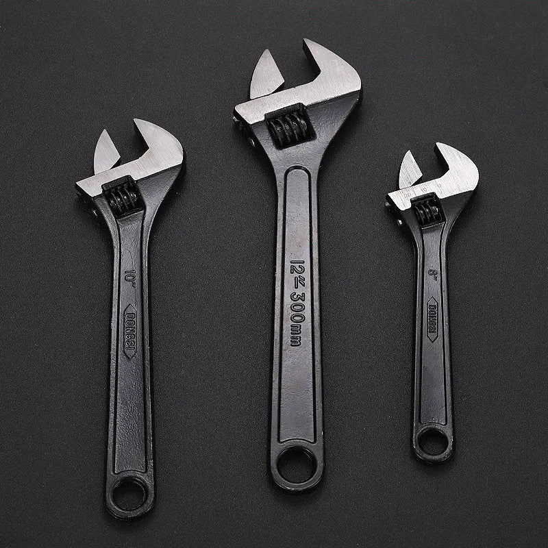10-inch black high carbon steel adjustable open-end wrench on a workbench.