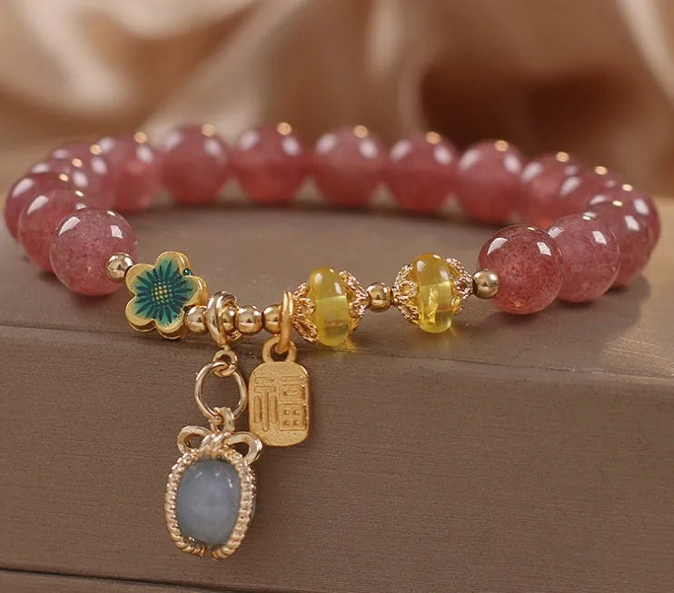 Red women's bracelet with natural strawberry quartz beads, alloy settings, and rhinestone decorative elements