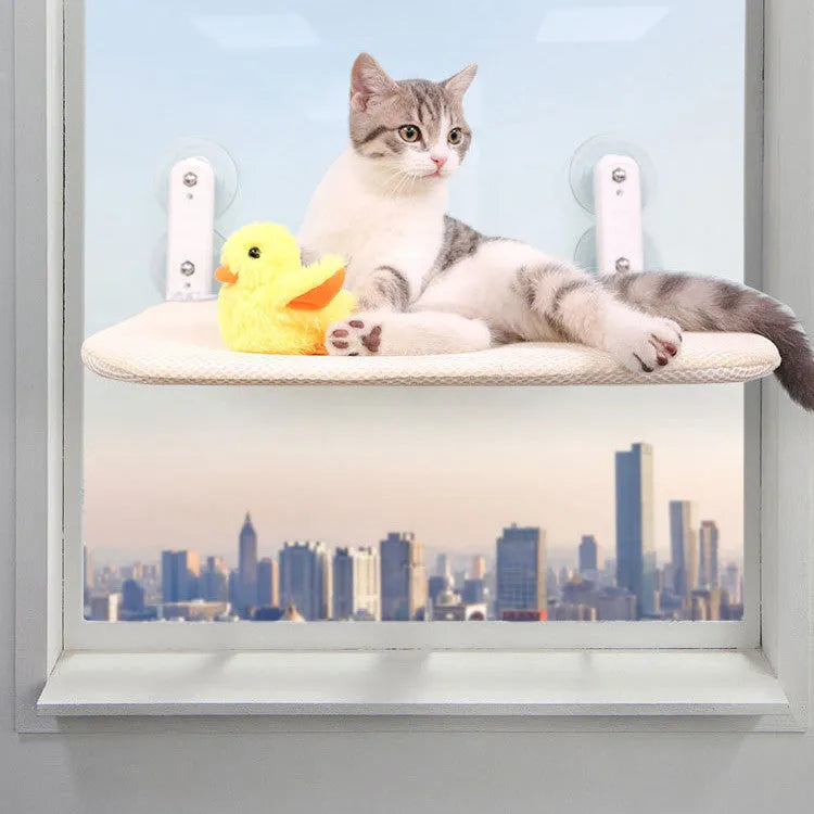 Grey plush foldable cat hammock bed attached to a window with stainless steel suction cups
