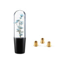 Transparent crystal car gear knob with floating flower inside, shown with three metal adapters.
