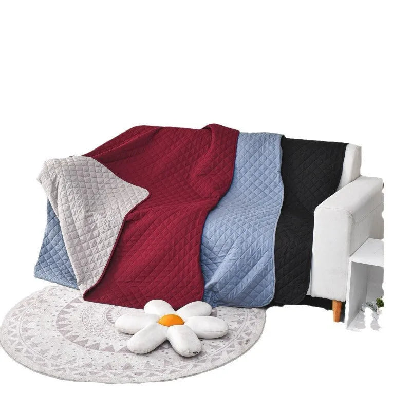 Reversible waterproof dog blanket on a sofa in burgundy colour, showing double-sided design