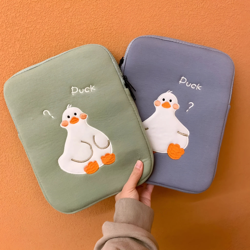 Blue cotton tablet case with embroidered cartoon duck design and a zipper, sized for an iPad.