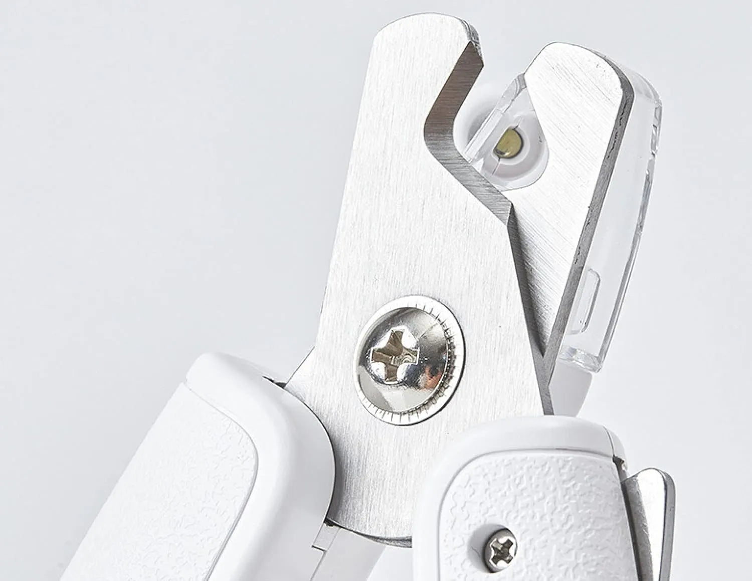 White pet nail clippers with LED light, transparent guard, and a nail file on a table