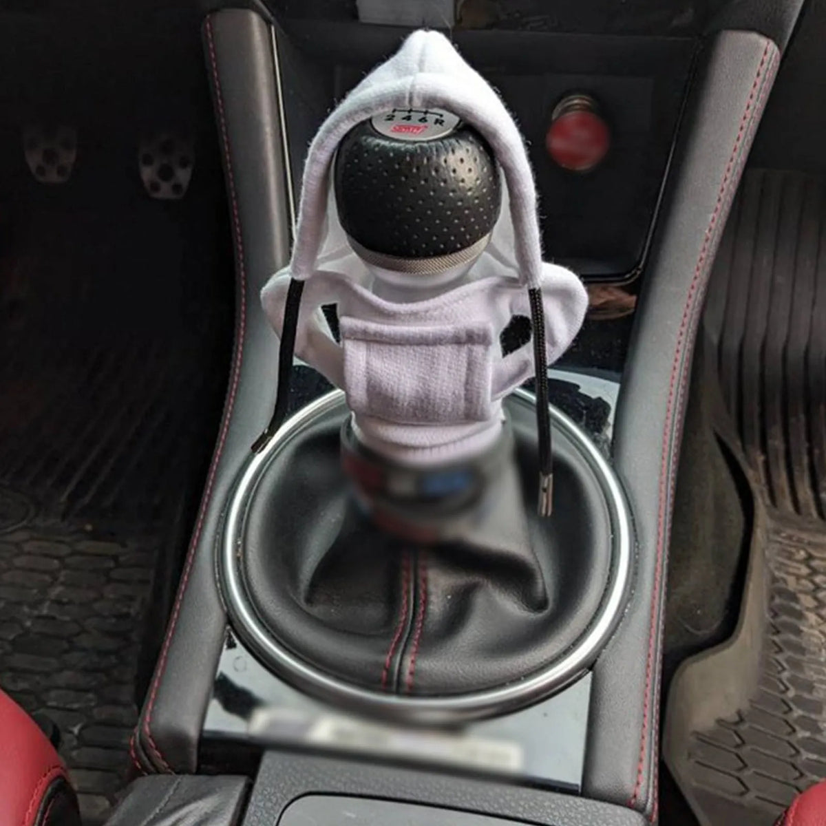 Universal cotton gear knob cover hoodie in blue with adjustable drawstring on a car shift knob