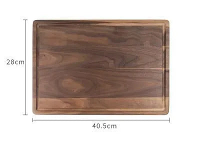 Black walnut wood cutting board with sauce groove and carved side handle on kitchen counter