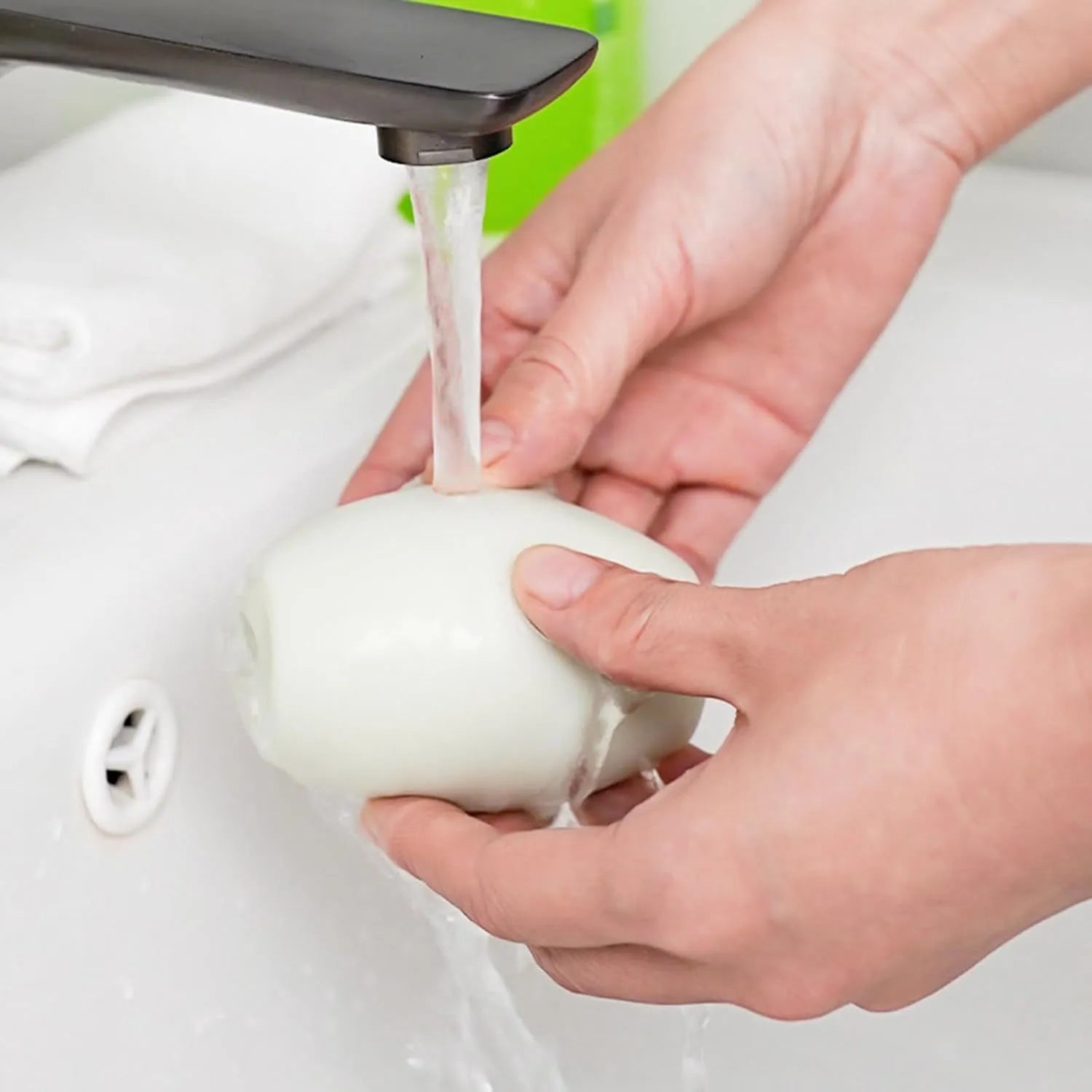 Green and white reusable gel lint roller ball for pet hair removal on fabrics