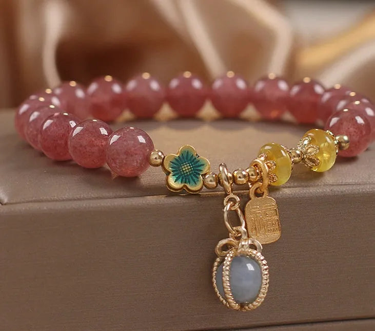 Red women's bracelet with natural strawberry quartz beads, alloy settings, and rhinestone decorative elements