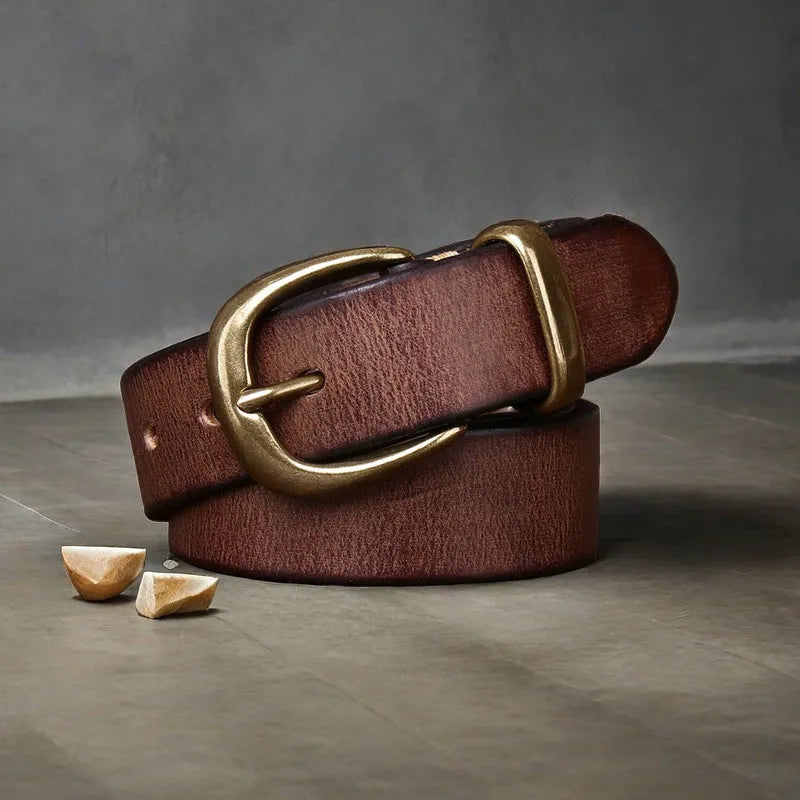 Men's black casual leather belt with a copper pin buckle on a jeans background.