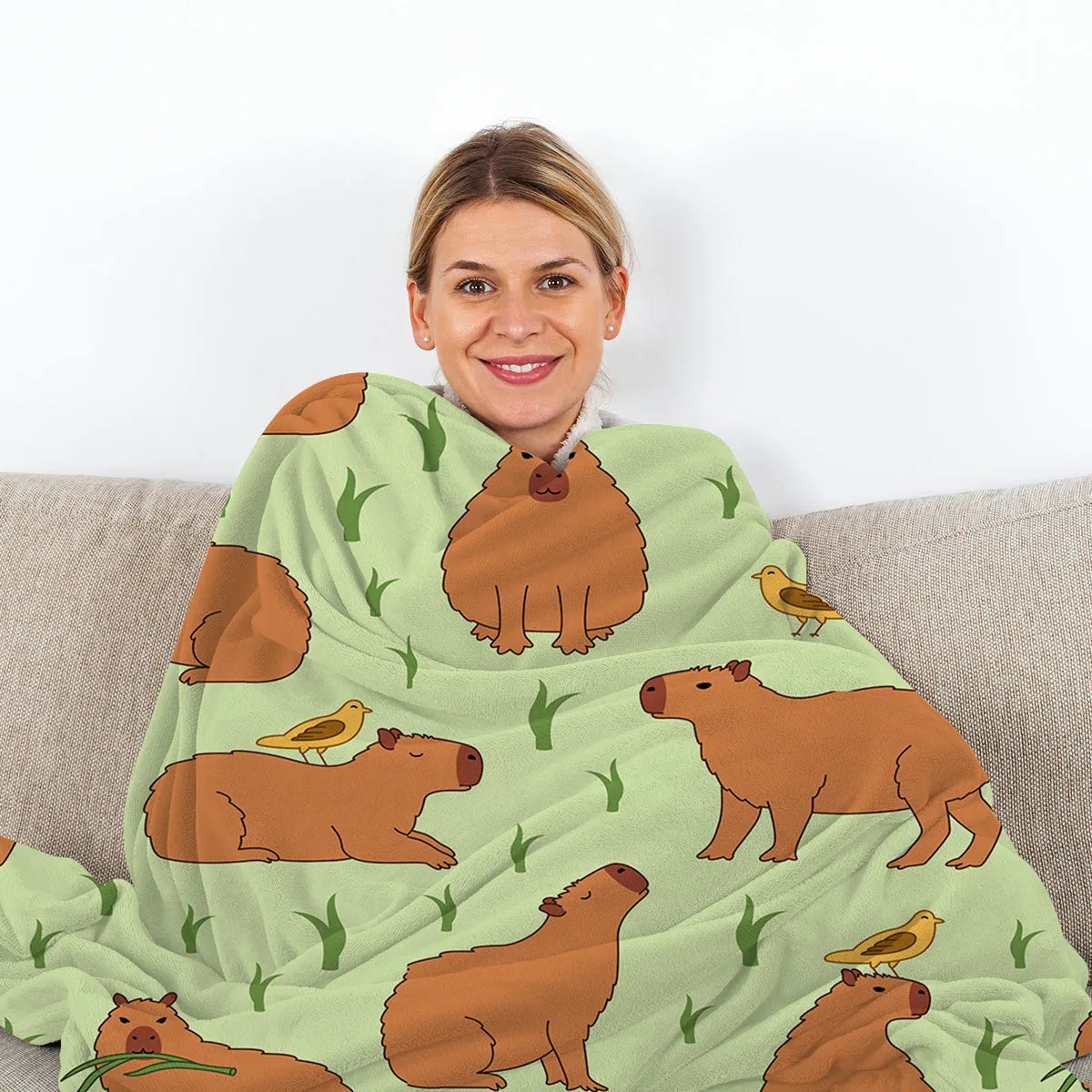 Multicolored flannel blanket with bird and capybara combined pattern on a sofa