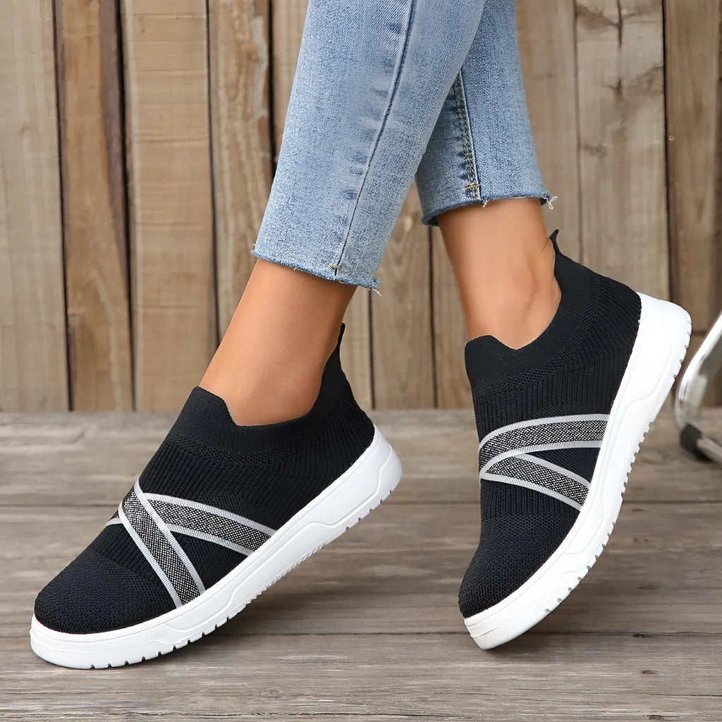Black women's flat casual shoes with fabric mesh uppers, tassel detail, and a rubber sole.
