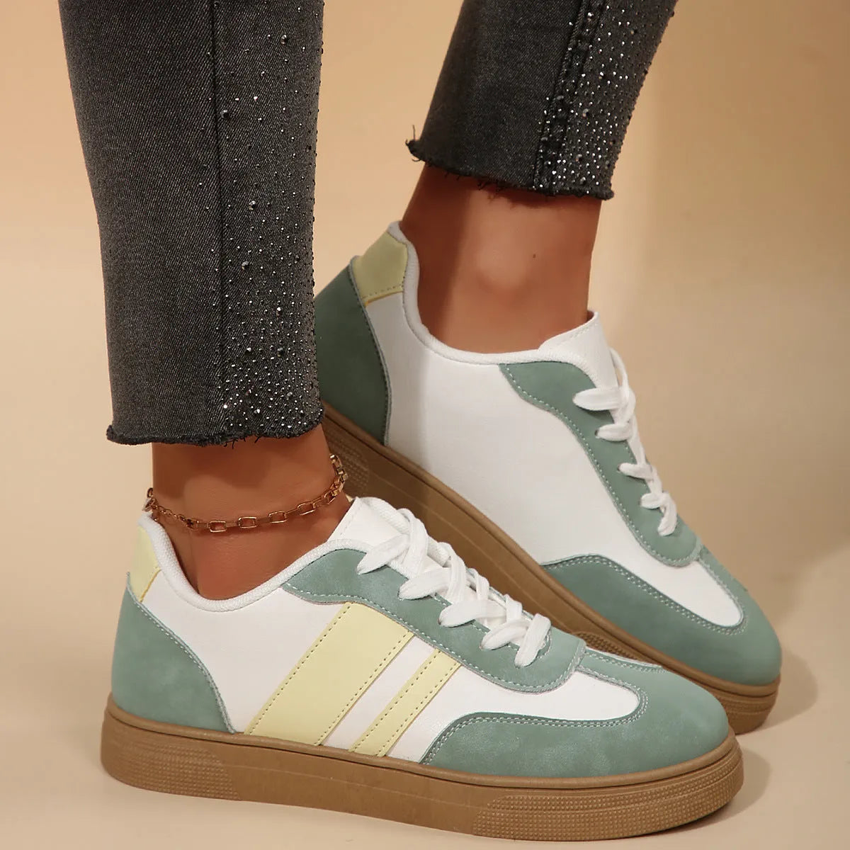 Green women's retro sports pumps with cross straps, flat rubber sole, and round toe on a white background.