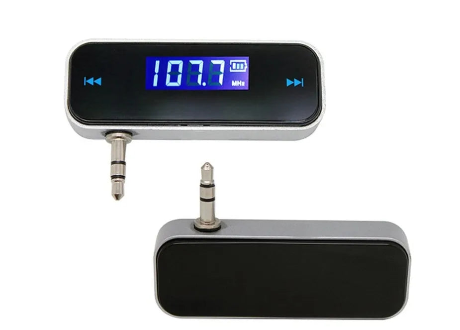 Black car FM transmitter with LCD display showing FM frequency, 3.5mm aux plug connected to smartphone