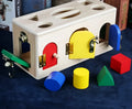 Wooden educational shape sorting lock box toy with coloured blocks for preschool children.
