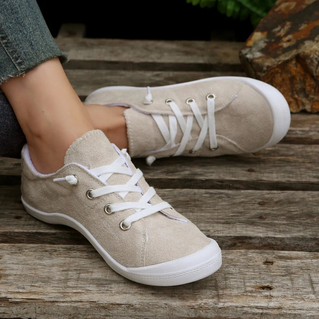 Women's creamy-white low-top fabric casual sneakers with a rubber sole on a neutral background.