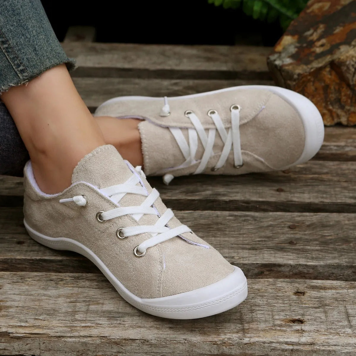 Women's creamy-white low-top fabric casual sneakers with a rubber sole on a neutral background.