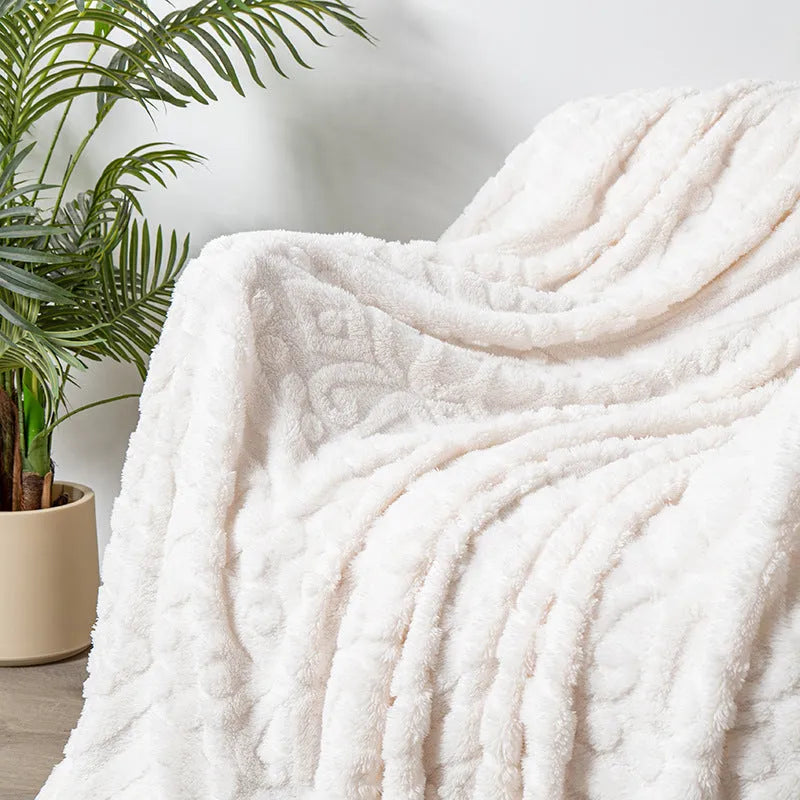 Soft cotton velvet jacquard sofa blanket in a solid colour draped over a modern sofa.