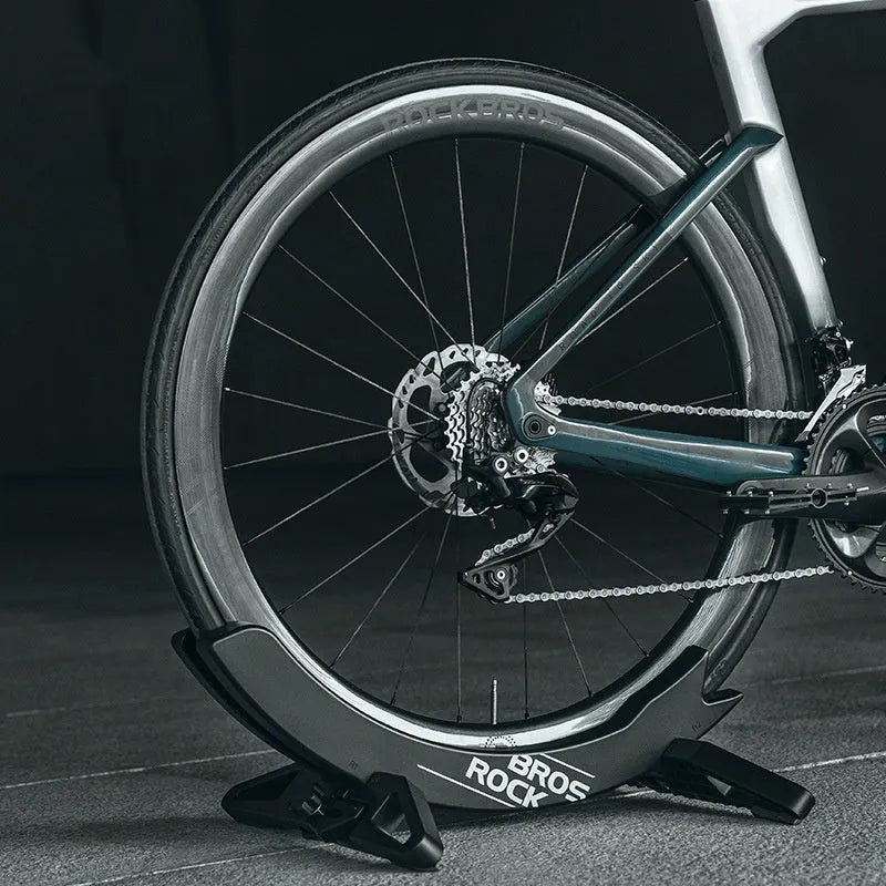 Black ABS plastic bicycle parking rack holder mounted on wall with mountain bike