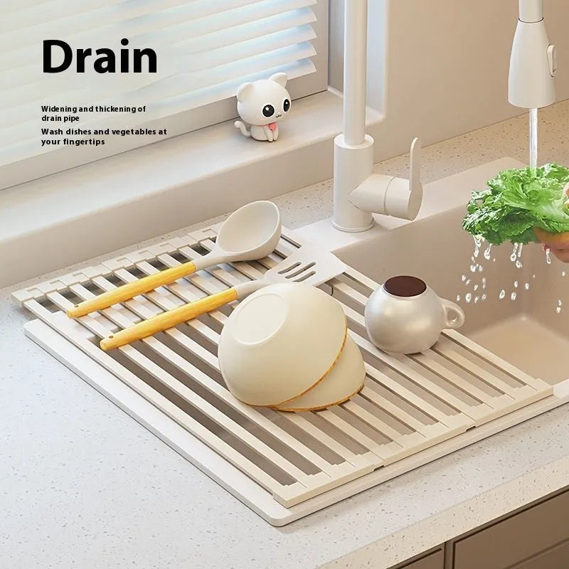 Foldable milky white stainless steel kitchen draining rack with dishes, shown next to a sink.