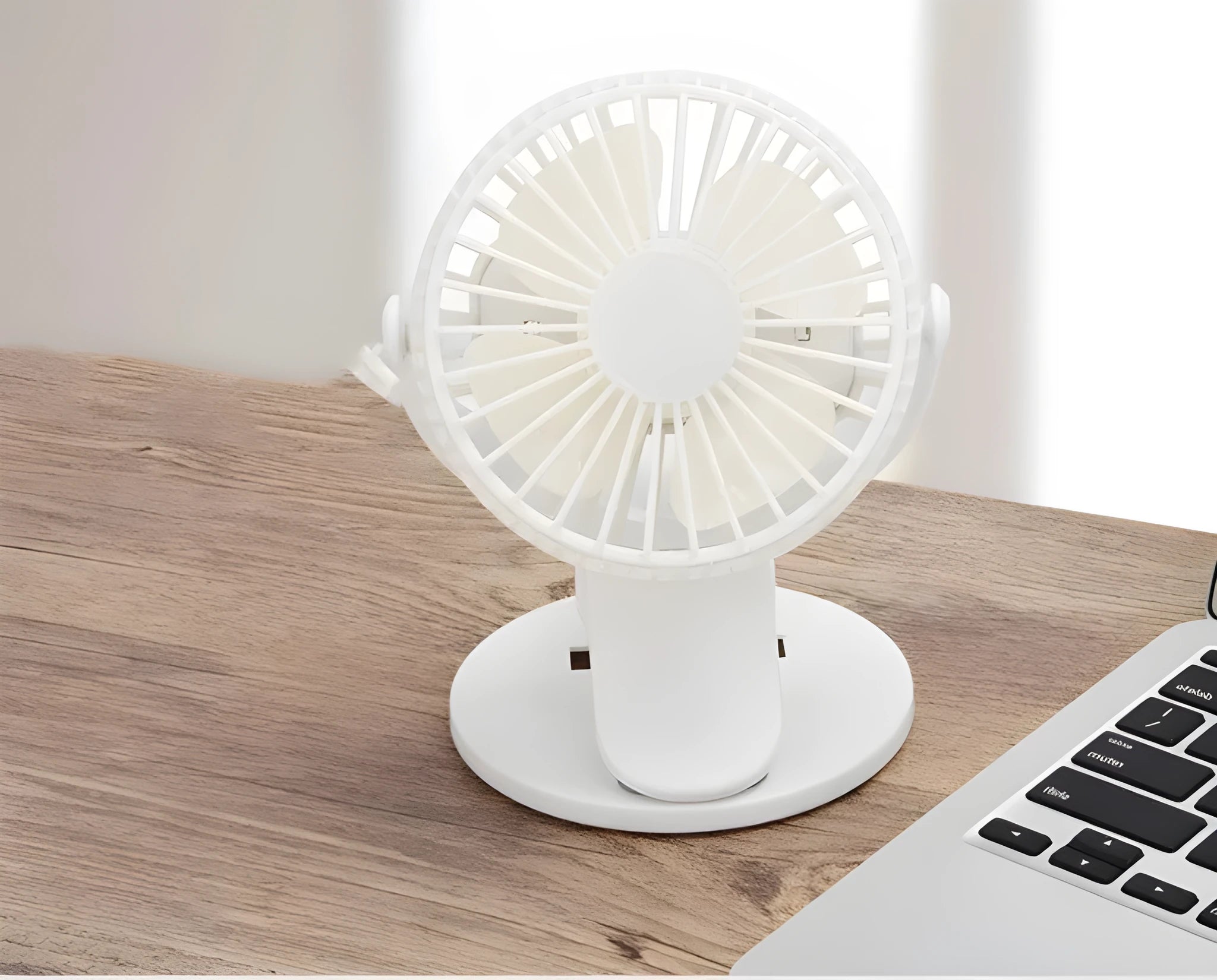 Small white USB rechargeable clip fan with plastic blades attached to desk edge