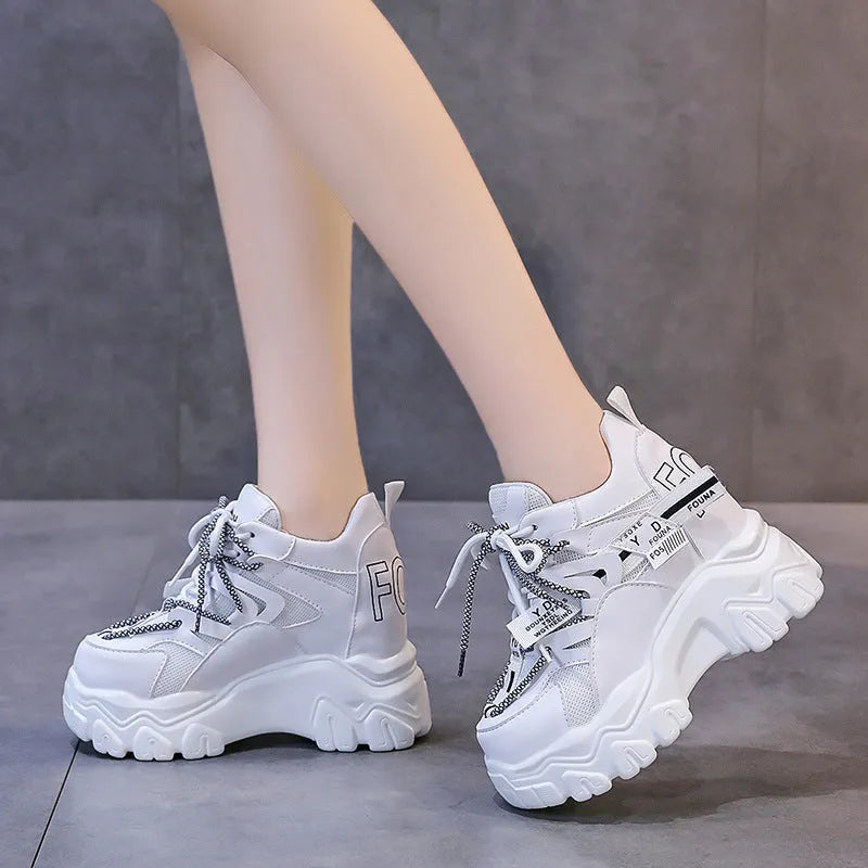 White women's low-top platform trainers with breathable mesh and a black cross-strap.