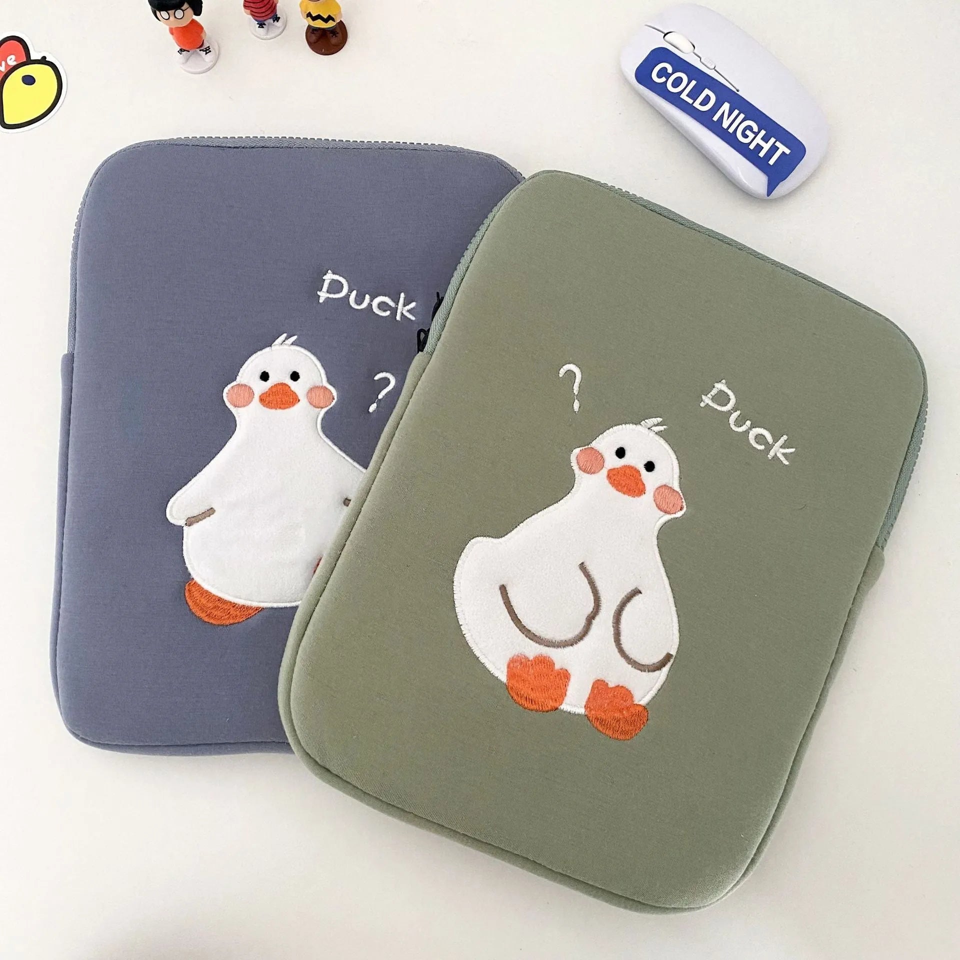 Blue cotton tablet case with embroidered cartoon duck design and a zipper, sized for an iPad.