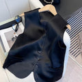 Black sleeveless satin vest for women on a hanger, showing loose fit and normal length.