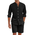 Man wearing a dark grey short-sleeve lapel shirt and matching drawstring shorts from a hemp-blend linen summer suit set.