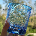 Hand-carved sky blue crystal whiskey shot glass on a wooden surface, 90x100mm size