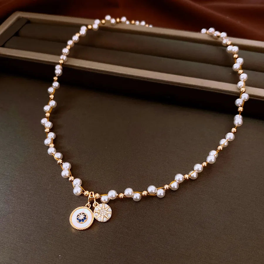 Golden-white electroplated necklace with round pearl pendant on adjustable clavicle chain