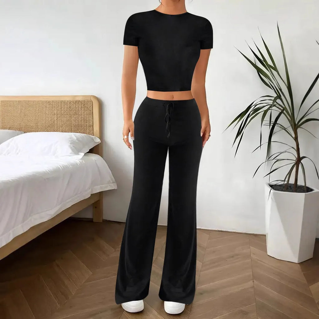 Black high-waist trousers and short-sleeve T-shirt co-ord set laid flat.