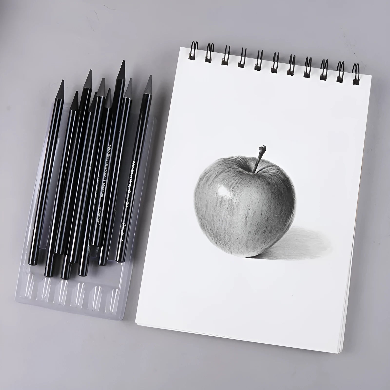 Set of six graphite pencils and three carbonized pencils packaged on a white suction card.