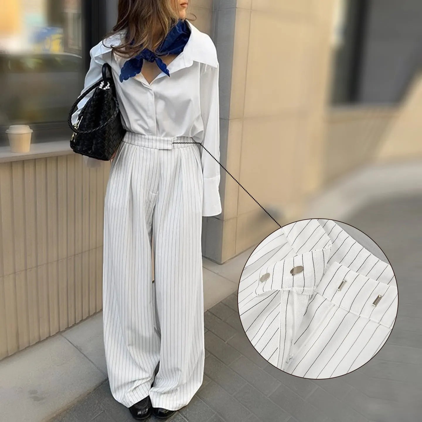 White striped wide-leg women's trousers with a loose fit and zipper fastening on a hanger.