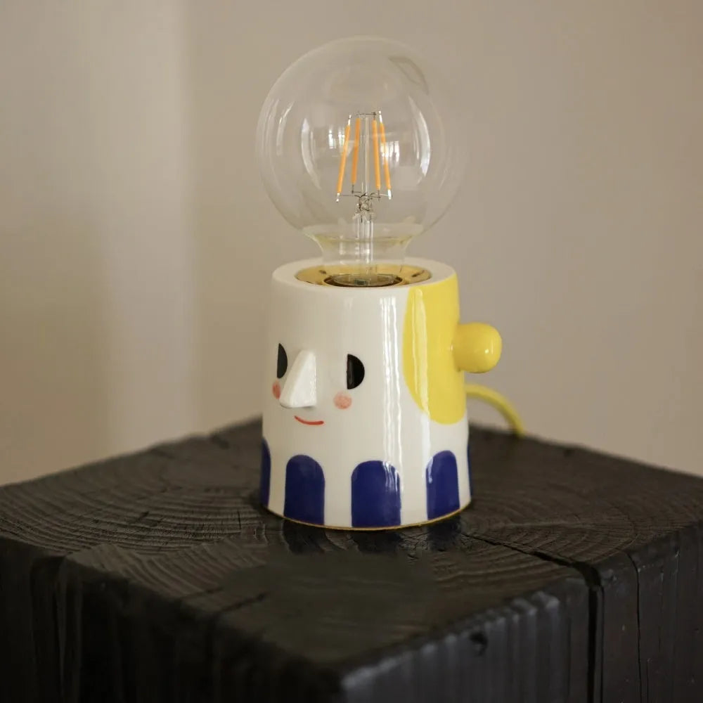 Handmade ceramic bedside lamp with ball headlight design on wooden nightstand