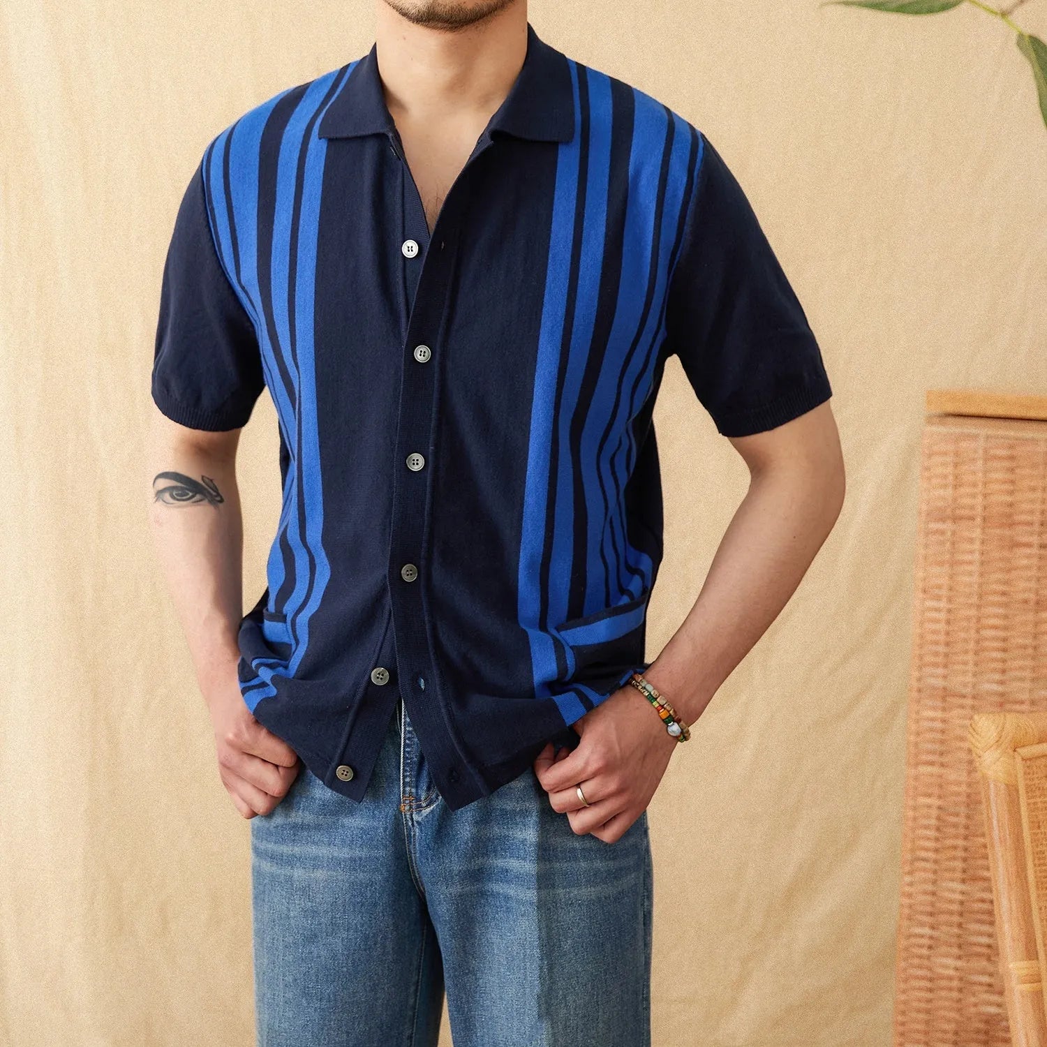 A man wearing a light blue striped short sleeve polo cardigan shirt with a lapel collar.