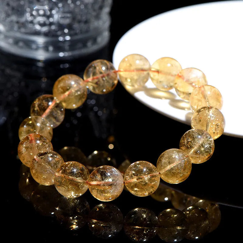 Natural yellow citrine gemstone bracelet with geometric beads on a white background.
