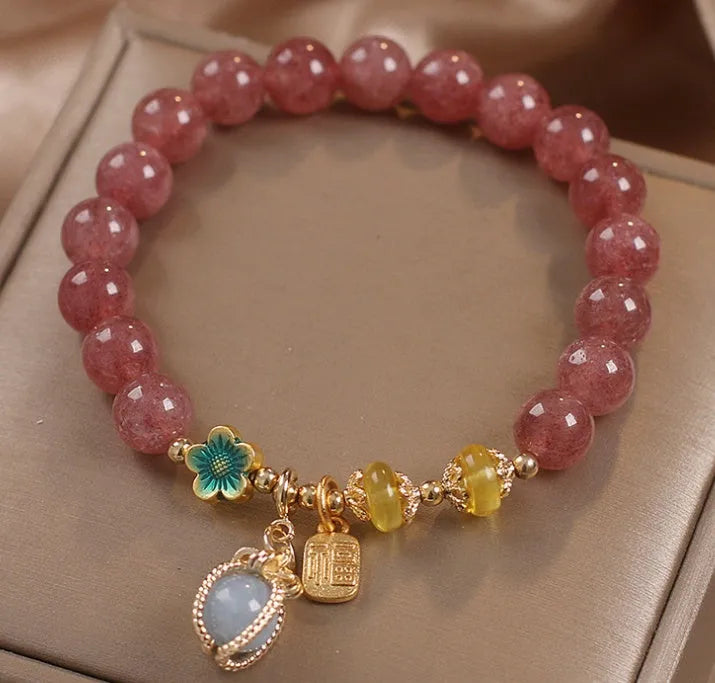 Red women's bracelet with natural strawberry quartz beads, alloy settings, and rhinestone decorative elements