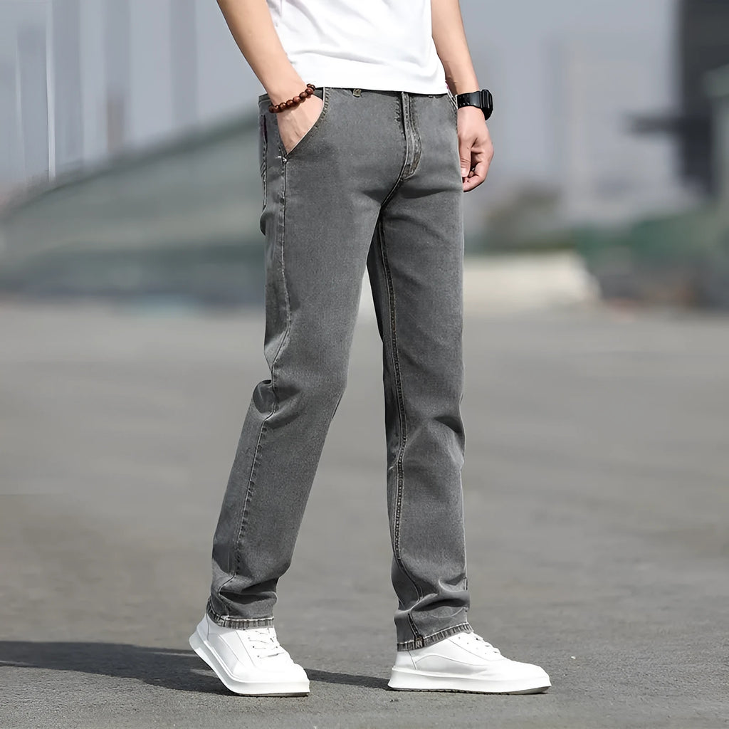 Men's smoky grey straight leg jeans with low waist design and zipper fly closure