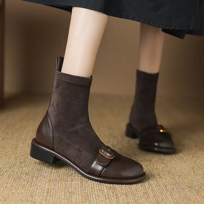 Women's black low heel ankle boots with martin-style buckle stitching and white lace-up front.